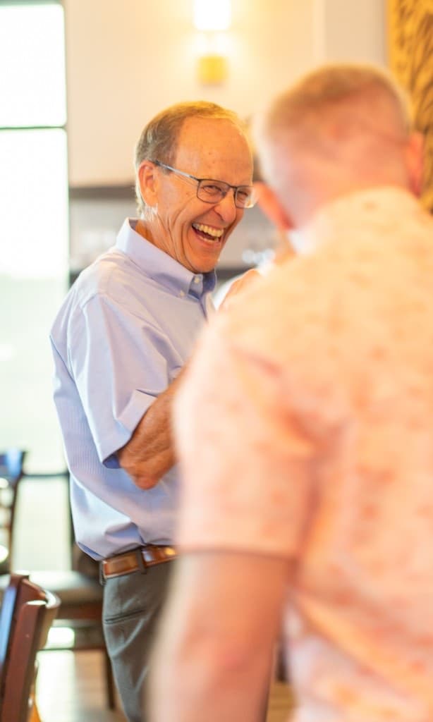 Man laughing in conversation across a table